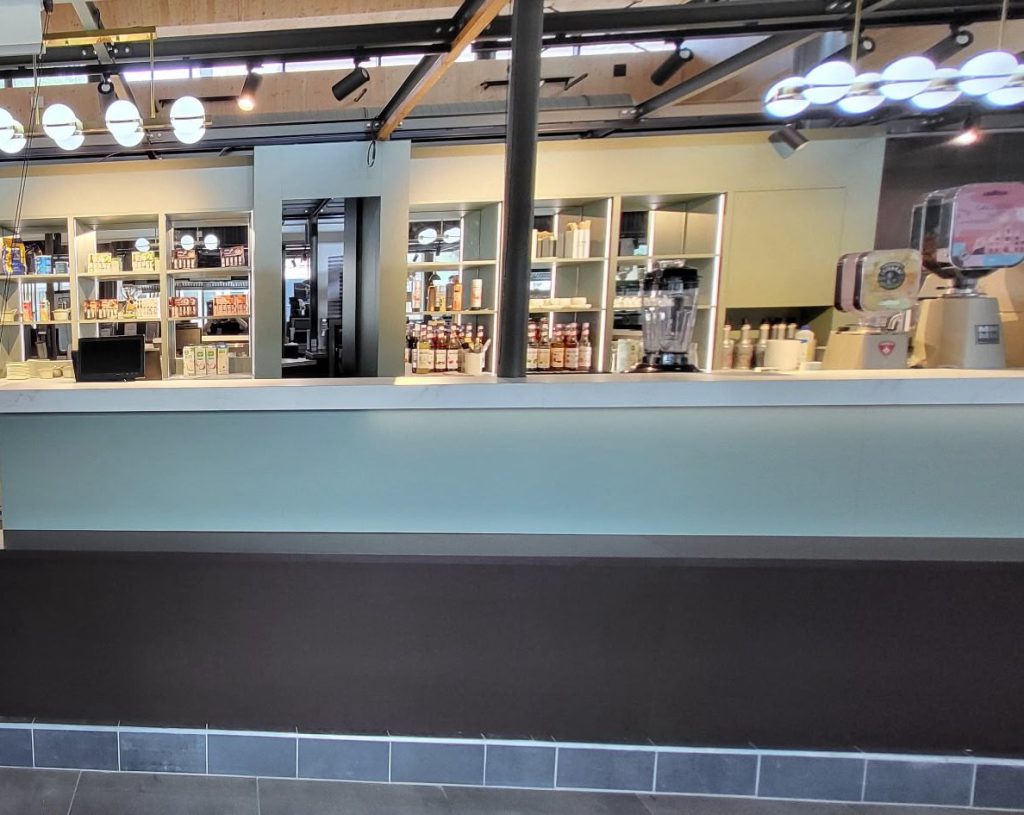 Comptoir du stand vu de face, devant les étagères éclairées
